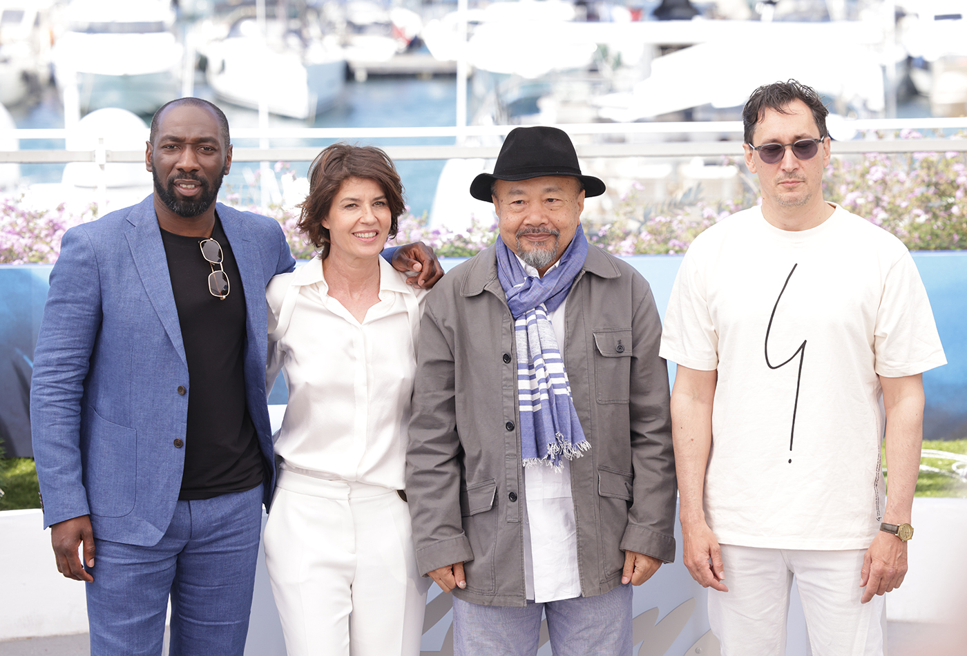 Rithy Panh surrounded by his cast at the Palais du Festival , cannes 2024, photo by Marco Tassini