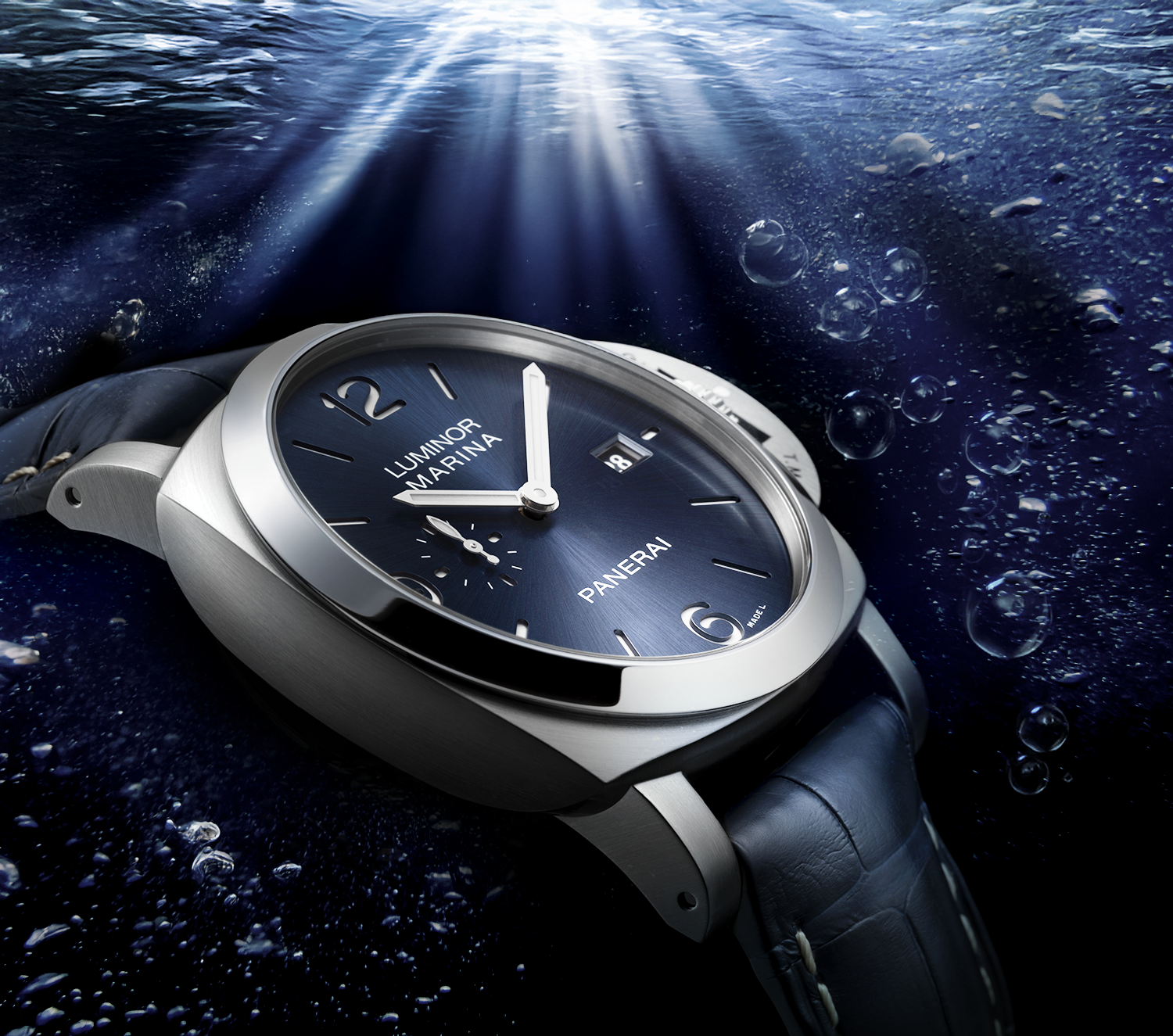 The PAM03313 is equipped with a self-winding mechanical movement that displays hours, minutes, small seconds, and the date, offering a power reserve of three days. Housed in a 44mm case of satin-finished 316L stainless steel with a polished bezel and sapphire crystal, it features a blue sandwich dial with luminous Arabic numerals and indexes. Complemented by a blue alligator strap with contrasting stitching and the PAM Click™ system for easy adjustment, this model is water-resistant to 50 BAR (~500 meters) and is priced at €8,900. image by artist Alexandra Mas